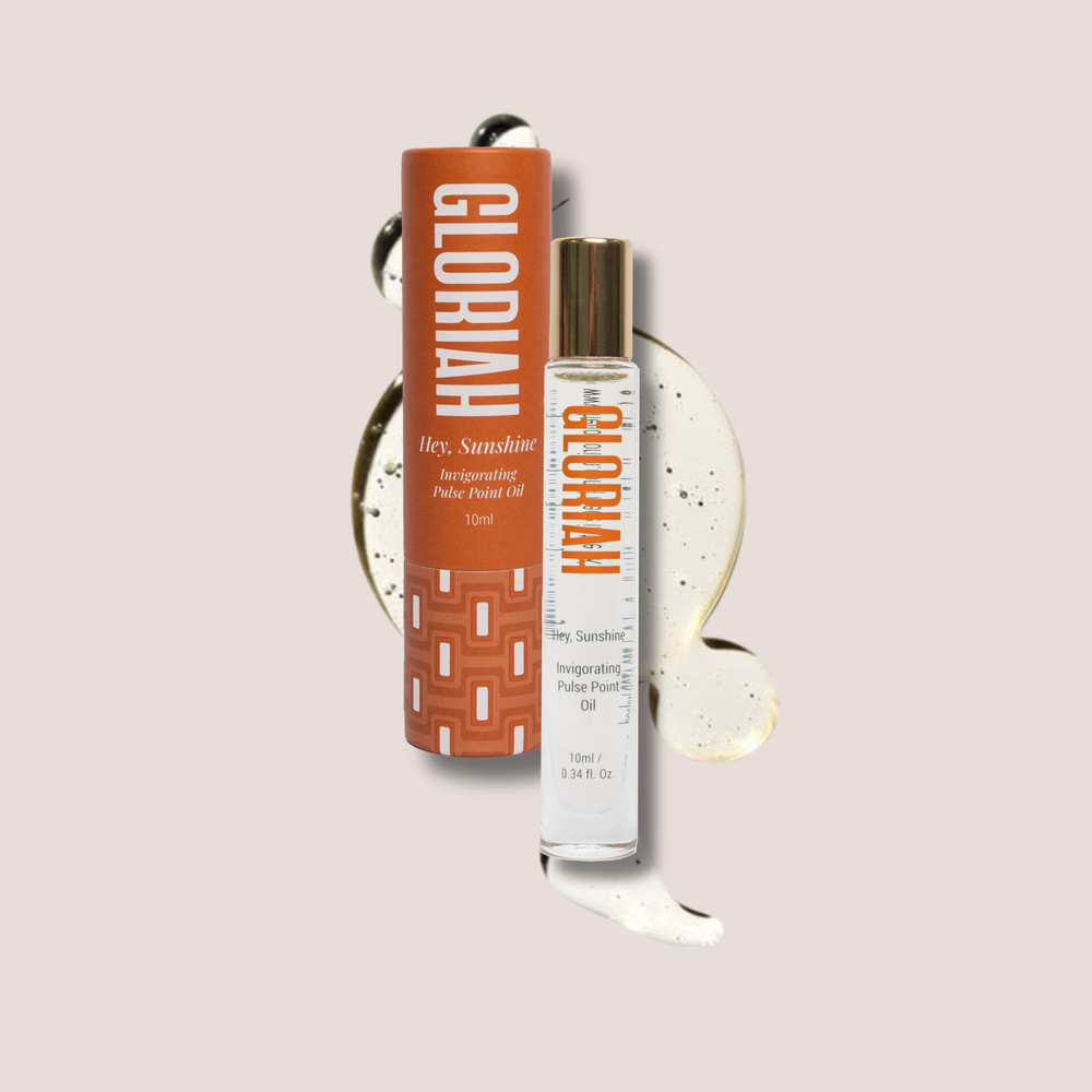 GLORIAH Hey, Sunshine Roller-Oil 10ml bottle with its orange cardboard packaging, displayed on a light beige background with decorative cream and black swirls