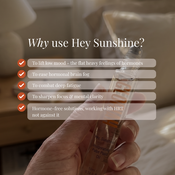 A hand holds a clear glass rollerball bottle labeled Hey Sunshine hormone-free pulse oil against a softly blurred warm indoor background. White text overlays read 'Why use Hey Sunshine?' with check marks and benefit points.